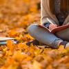 Student sitting in autumn leaves