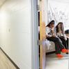 Two students sitting on a dorm bed
